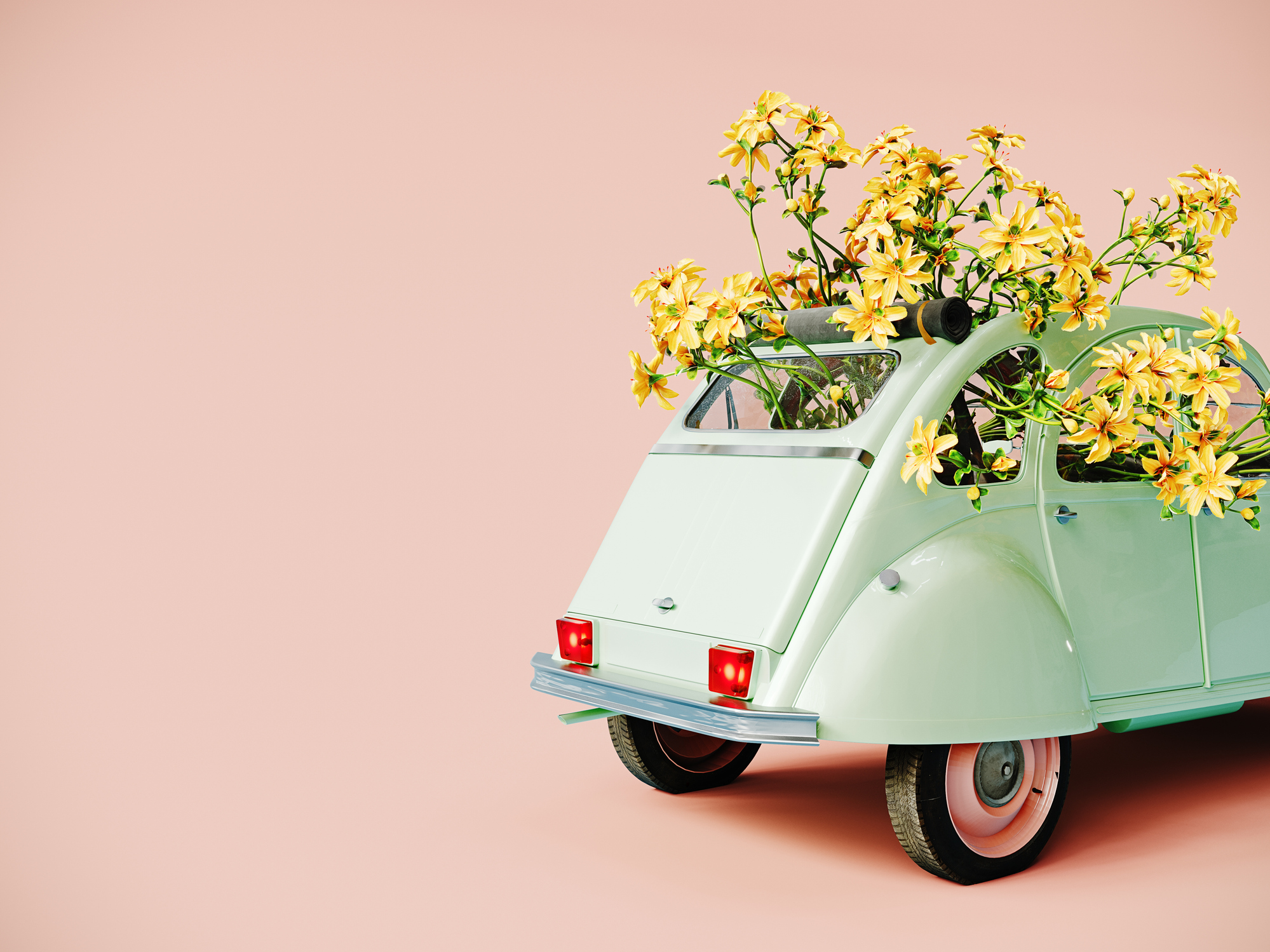 Old mint green retro car full of yellow flowers on pink background with copy space